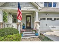 Charming front porch with stone pillars, American flag, and a well-manicured garden at 2686 Oak Leaf Se Pl, Atlanta, GA 30316