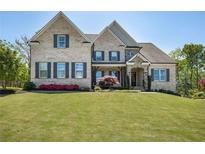Elegant brick home featuring a manicured lawn, symmetrical design, and inviting front porch at 5335 Briarstone Ridge Way, Alpharetta, GA 30022