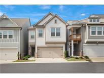 Charming two-story townhome with a two-car garage and manicured landscaping, complemented by a well-maintained facade at 354 Hayden Cir, Woodstock, GA 30189