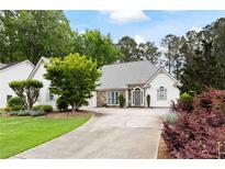 Charming home featuring a stone and siding facade, well-manicured lawn, and a welcoming driveway at 5042 Southland Dr, Woodstock, GA 30188