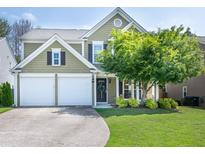 Charming two-story home with a two-car garage, beautiful green lawn, and mature landscaping at 6030 Pattingham Dr, Roswell, GA 30075