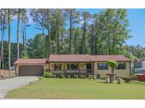 Ranch style home with a covered porch, large front yard, and an attached two car garage at 3814 Lamar Way, Snellville, GA 30039