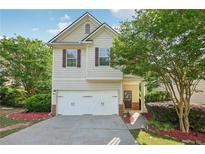 Charming two-story home with a well-manicured lawn, attached garage, and inviting front porch at 6071 Apple Grove Rd, Buford, GA 30519