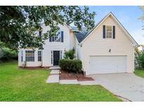 Charming two-story home featuring a well-manicured lawn and a two-car garage, creating an inviting curb appeal at 137 Legend Creek Dr, Canton, GA 30114