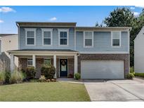 Charming two-story home featuring a covered porch, a brick facade, and a two-car garage at 5437 Blossom Brook Dr, Sugar Hill, GA 30518