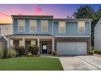 Charming two-story home features a two-car garage, manicured lawn and is beautifully landscaped at 5437 Blossom Brook Dr, Sugar Hill, GA 30518