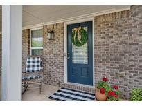 Charming brick home featuring a welcoming blue front door adorned with a decorative wreath at 5437 Blossom Brook Dr, Sugar Hill, GA 30518