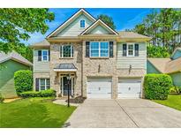 Charming two-story home with a brick and siding exterior, complemented by a well-manicured lawn and a two car garage at 525 Roland Manor Dr, Dacula, GA 30019