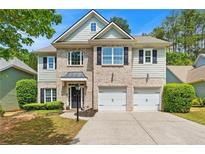 Beautiful two-story home featuring brick and siding exterior, attached two car garage, and manicured front yard at 525 Roland Manor Dr, Dacula, GA 30019