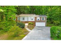 Charming single-story brick home featuring a well-manicured front yard, and a two-car attached garage at 1584 Allgood Ne Rd, Marietta, GA 30062