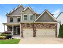 Charming two-story home with stone accents, manicured lawn, and a two-car garage at 626 Discovery Ct, Acworth, GA 30102