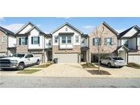 Attractive townhomes featuring a two-car garage and a mix of stone and siding exterior at 1388 Ben Park Way, Grayson, GA 30017