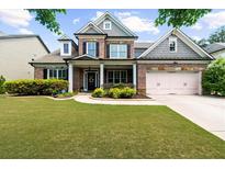 Charming brick two-story home with manicured lawn and attached two-car garage at 1156 Whisper Cove Dr, Buford, GA 30518