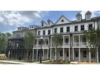 Modern townhome exteriors featuring covered front porches and light brick at 1975 Flying Scotsman Dr # 18, Kennesaw, GA 30144