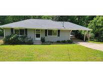 Charming single story home with a well maintained lawn, beautiful shrubbery, and convenient covered parking at 3844 Davis St, Suwanee, GA 30024
