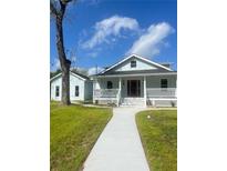 Charming light blue home with inviting front porch and well-maintained lawn on a beautiful day at 5191 Nw Emory Nw St, Covington, GA 30014