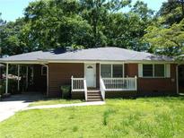 Charming single-story house with a brick and wood facade, cozy front porch, and a well-shaded lawn at 732 Vinson Sw Pl, Atlanta, GA 30315