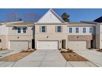 Charming townhome with a two-car garage and brick and siding facade, set on a sunny day at 4525 Twinberry Dr, Powder Springs, GA 30127
