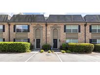 Charming townhouse exterior with brick facade, black shutters, and well-manicured greenery at 6980 Roswell Rd # G3, Atlanta, GA 30328