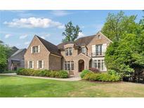 Charming brick home featuring a well-manicured lawn and mature landscaping with a beautiful entrance at 1740 Doncaster Ne Dr, Atlanta, GA 30309