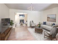 Bright living room features hardwood floors, neutral paint, modern furniture, and a smooth transition to a living space at 143 Lablanc Nw Way, Atlanta, GA 30327