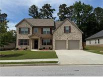 Charming two-story home with a well-manicured lawn, brick facade, and a two-car garage at 3531 Lilly Brook Dr, Loganville, GA 30052