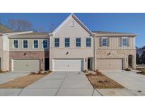 New townhome exteriors with brick and siding accents, set against a bright blue sky backdrop at 4517 Twinberry Dr, Powder Springs, GA 30127
