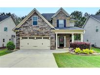 Charming two-story home with a stone and brick facade, two-car garage, and well-maintained landscaping at 6468 Pierless Ave, Sugar Hill, GA 30518