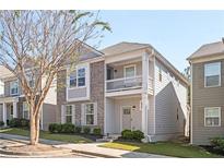 Charming two-story home with gray siding, brick accents, a cozy balcony, and well-maintained landscaping at 875 Venture Sw Way, Atlanta, GA 30331