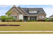 Charming home featuring stone accents, dormer windows, and manicured front lawn at 170 Oakleigh Manor Dr, Fayetteville, GA 30215