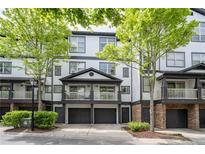 Charming townhome featuring a covered balcony, two-car garage, and manicured landscaping at 220 Semel Cir # 150, Atlanta, GA 30309