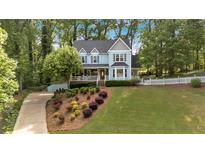 Charming two-story home with a landscaped yard, inviting front porch, and a classic picket fence at 4853 Ridgewood Creek Nw Dr, Acworth, GA 30102