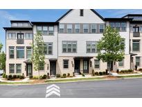 Charming townhome showcasing a blend of brick and siding, complemented by lush landscaping at 2669 Caruso Way, Atlanta, GA 30339