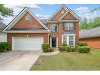 Charming two-story brick home featuring a well-manicured lawn and attached two-car garage at 7979 Larksview Dr, Fairburn, GA 30213