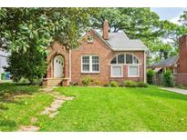 Charming brick home with a well-maintained lawn and arched doorway at 949 Hope Sw Dr, Atlanta, GA 30310