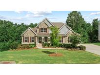 Beautiful home with manicured lawn, stone facade, dormer windows, and inviting entryway at 125 Registry Ln, Canton, GA 30115