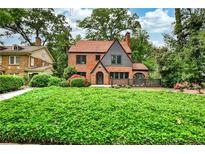 Charming brick Tudor-style home features a beautiful front yard and well-manicured landscaping at 50 Rumson Ne Way, Atlanta, GA 30305