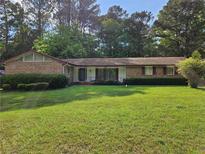 Charming brick home with a well-manicured lawn and mature trees in a quiet neighborhood at 417 Ohern Ct, Stone Mountain, GA 30088