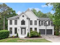 Beautiful two-story home featuring white brick, black window trim, attached two-car garage and landscaped front yard at 4294 Silver Peak Pkwy, Suwanee, GA 30024