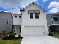 Charming two-story home with a white brick exterior, attached garage, and well-manicured landscaping at 4514 Eastbrook Pl, Snellville, GA 30039