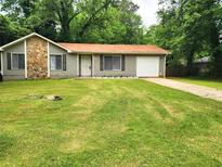 Charming one-story home with stone accents, a well-maintained lawn, and a private driveway at 8227 Englewood Trl, Riverdale, GA 30274