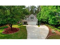 Charming home featuring a well-manicured front yard and a long driveway, nestled among mature trees at 95 Loudoun Dr, Covington, GA 30014