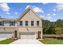 Charming new construction townhouse with a brick facade, well-manicured lawn, and attached garage at 4671 Larkfield Way, Powder Springs, GA 30127