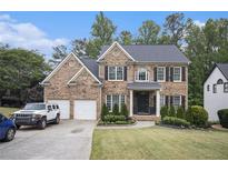 Charming two-story brick home featuring manicured landscaping and a three-car garage at 507 Southshore Ln, Dallas, GA 30157
