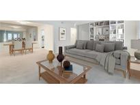 Bright living room featuring a large grey couch, decorative bookshelf, and an adjacent dining area at 6851 Roswell Rd # H1, Sandy Springs, GA 30328