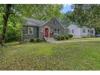 Charming brick bungalow with red door, landscaped yard, and inviting curb appeal at 2607 Jefferson Ter, Atlanta, GA 30344