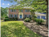 Charming two-story brick home with blue shutters and a well-manicured front yard at 3322 Woodsfield Ne Dr, Marietta, GA 30062