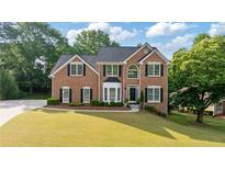 Beautiful brick home with a well-manicured lawn and mature trees showcasing classic architectural design at 455 Firelite Ln, Suwanee, GA 30024