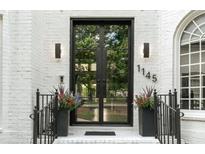 Elegant home entrance featuring a modern black framed glass double door and black metal railings at 1145 Lake Shore Overlook, Alpharetta, GA 30005