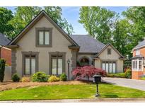 Charming home featuring a well-manicured lawn, neutral-toned stucco, complemented by a stone-accented facade and mature trees at 4569 Fountain Ne Dr, Marietta, GA 30067
